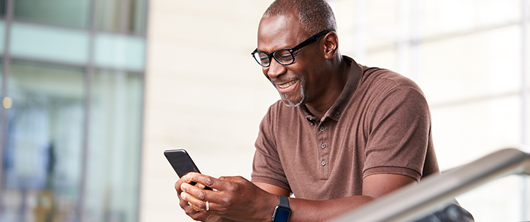  Older man checking phone and smiling