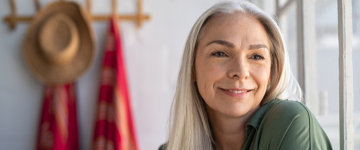 Older woman with long grey hair sitting by window