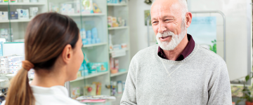 Senior man picking up prescription from pharmacy.