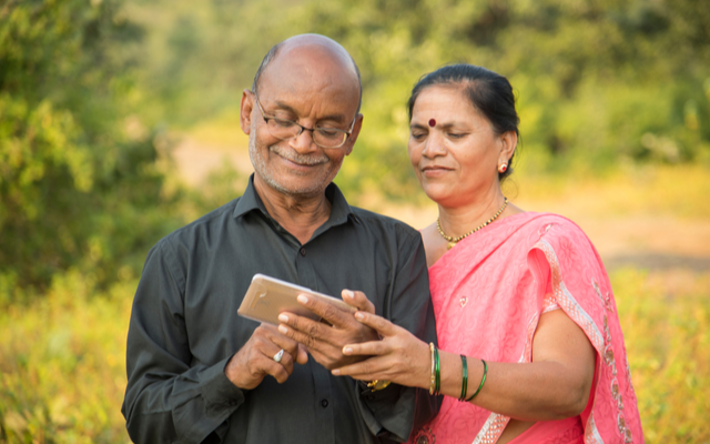 Older couple smiling at phone