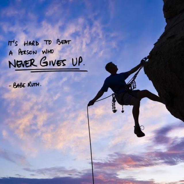 Image of the silhouette of a rock climber climbing a rock face with sky and clouds behind them.  Caption reads, "Its hard to beat a person who never gives up! -Babe Ruth"